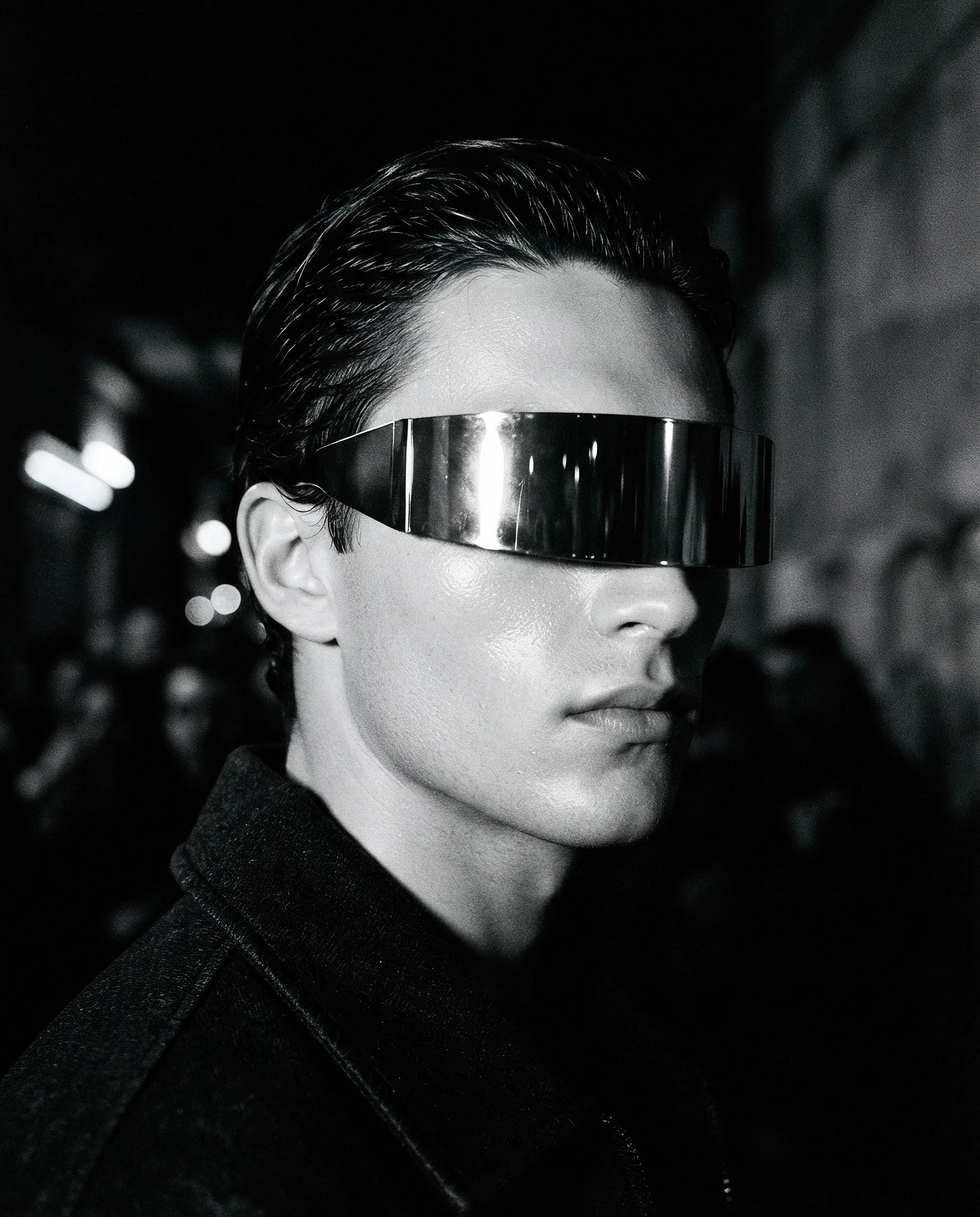 GRECALE — mirrored silver shield sunglasses on model, night flash portrait — angle view