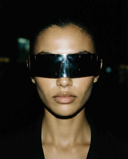 GRECALE — mirrored silver shield sunglasses on model, night flash portrait