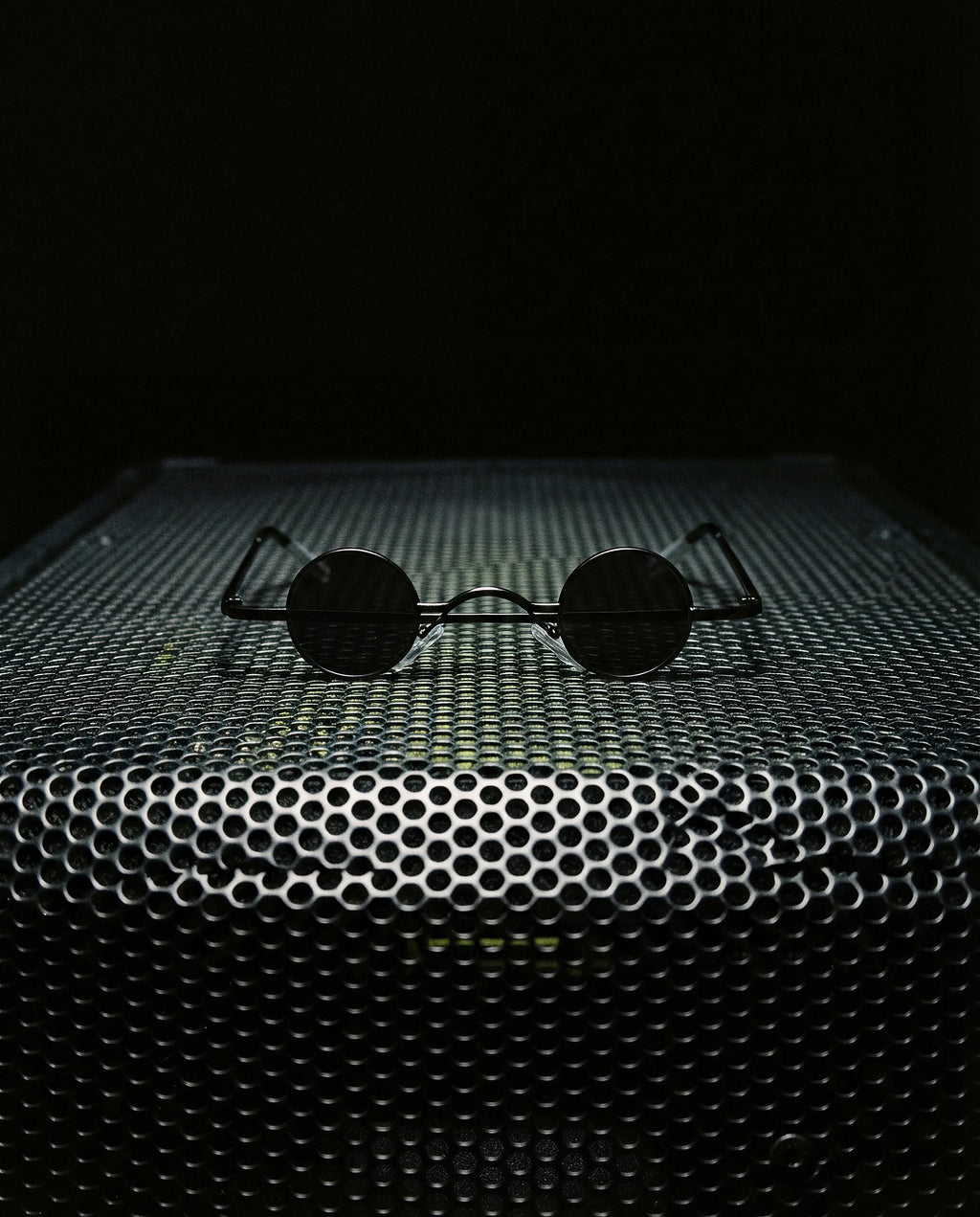 LIBECCIO — micro round sunglasses still life on speaker grille at night