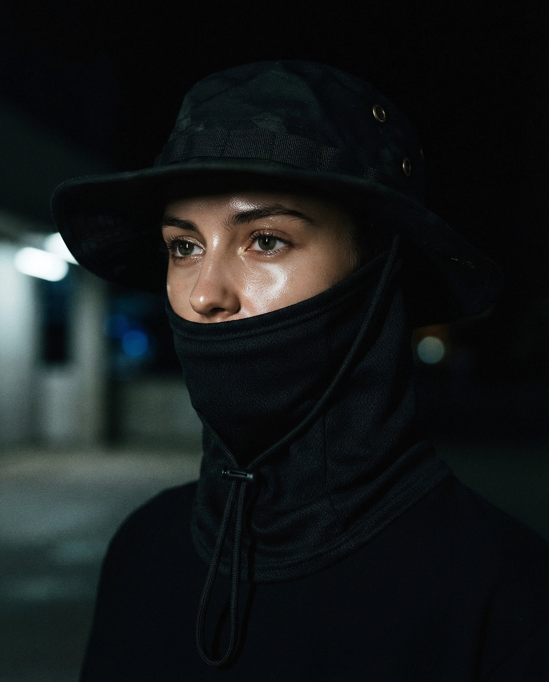NOTTURNO — black boonie hat with balaclava on model, night flash portrait — angle view