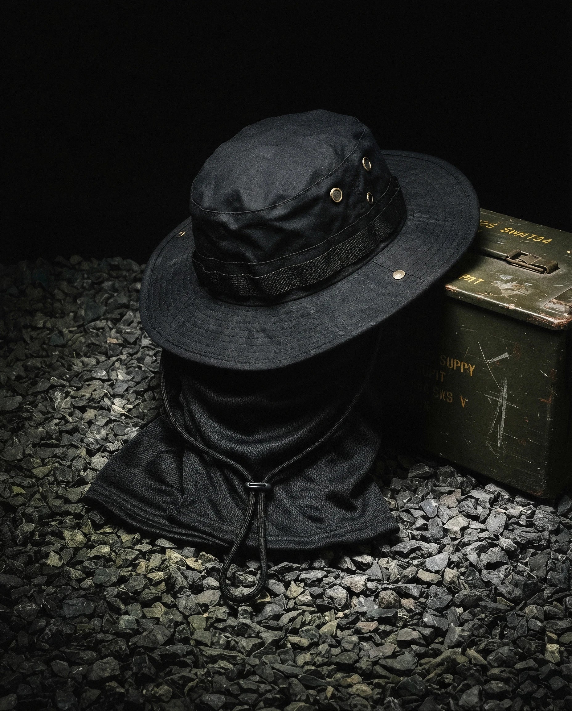 NOTTURNO — black boonie hat and balaclava set still life on gravel