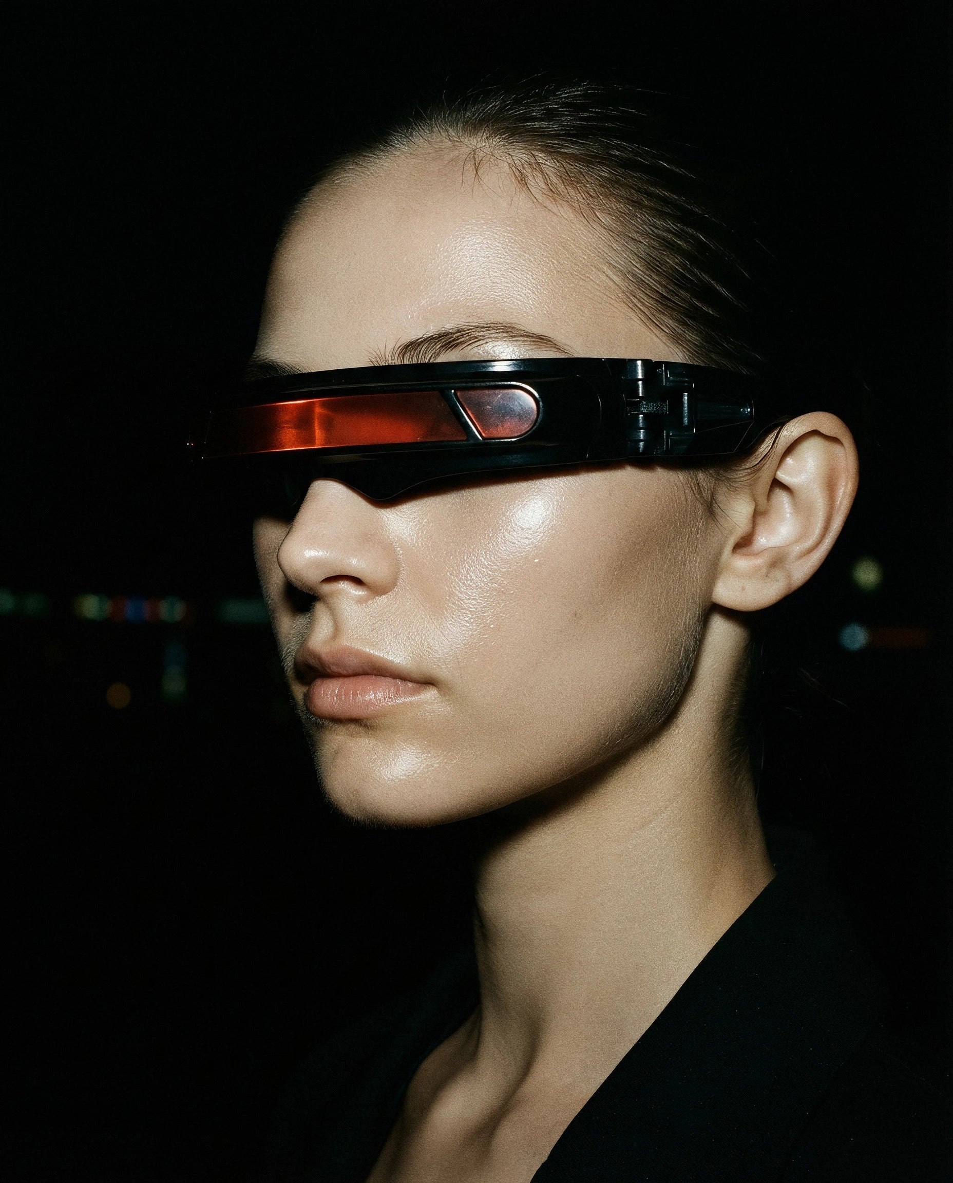 PONENTE — black single-band visor sunglasses with red lens strip on model, night flash portrait — angle view